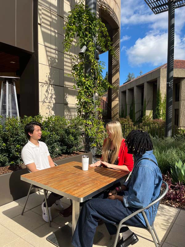 liftlab team members engaging in conversation at an outdoor table